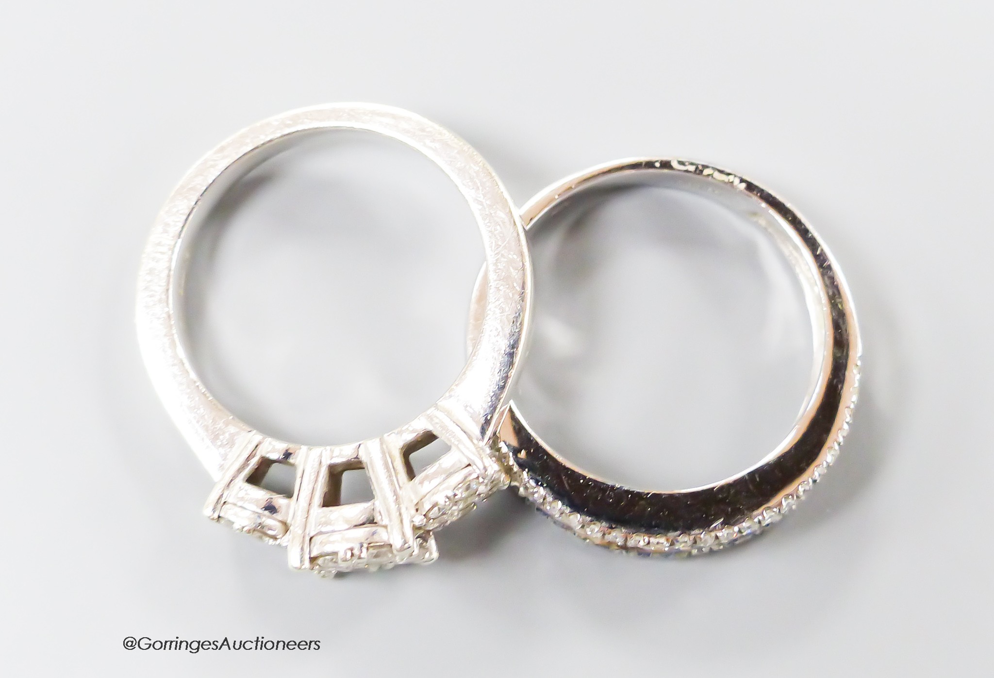 A modern 9ct white gold and triple diamond cluster set dress ring, size I/J and a similar sapphire and diamond set half hoop ring, size K, gross 6.5 grams.